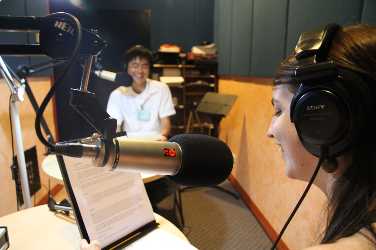 A young American girl speaks into the microphone in a sound recording studio